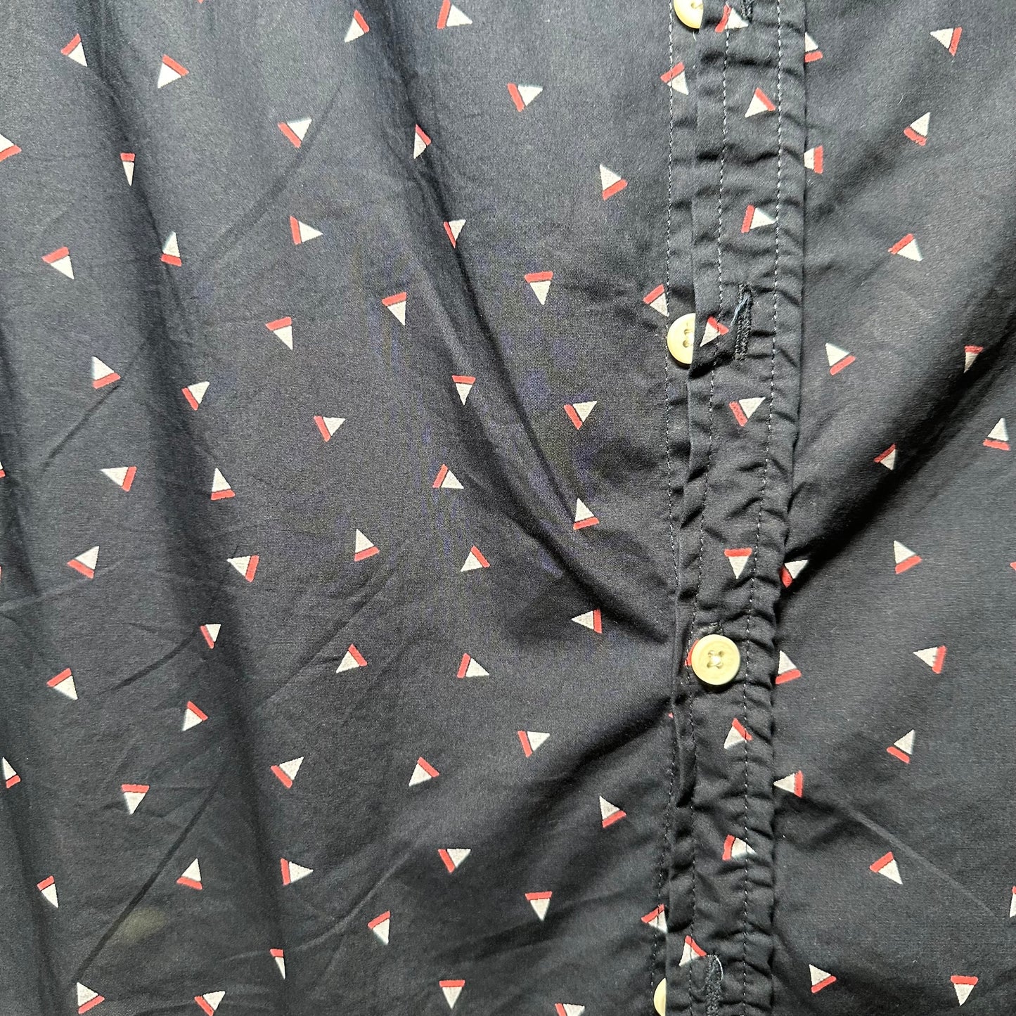 Close-up of a dark fabric with small triangle pattern and button details